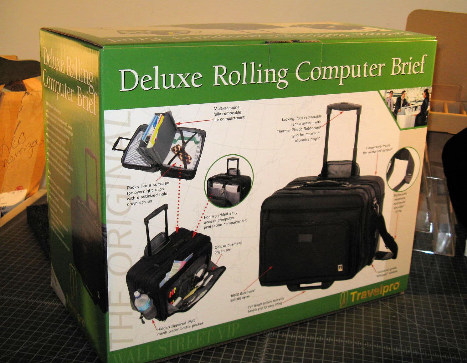 Green Travelpro box for a Deluxe Rolling Computer Brief showing the black bag's features.