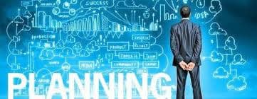 Businessman viewing a wall of business strategy sketches behind the large bold word PLANNING.